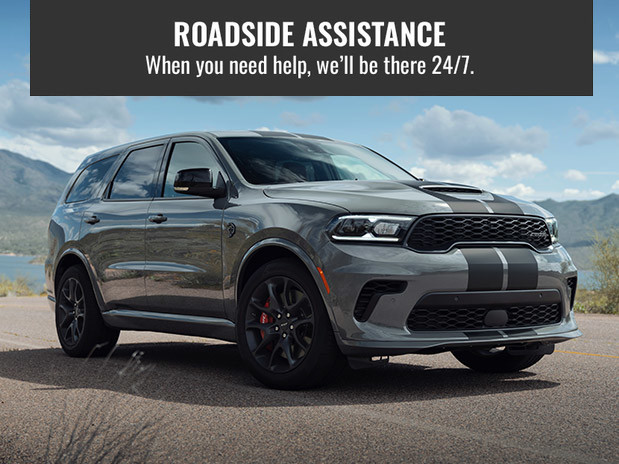 2021 grey Dodge Durango parked with mountain background. Roadside Assistance. When you need help, we'll be there 24/7.