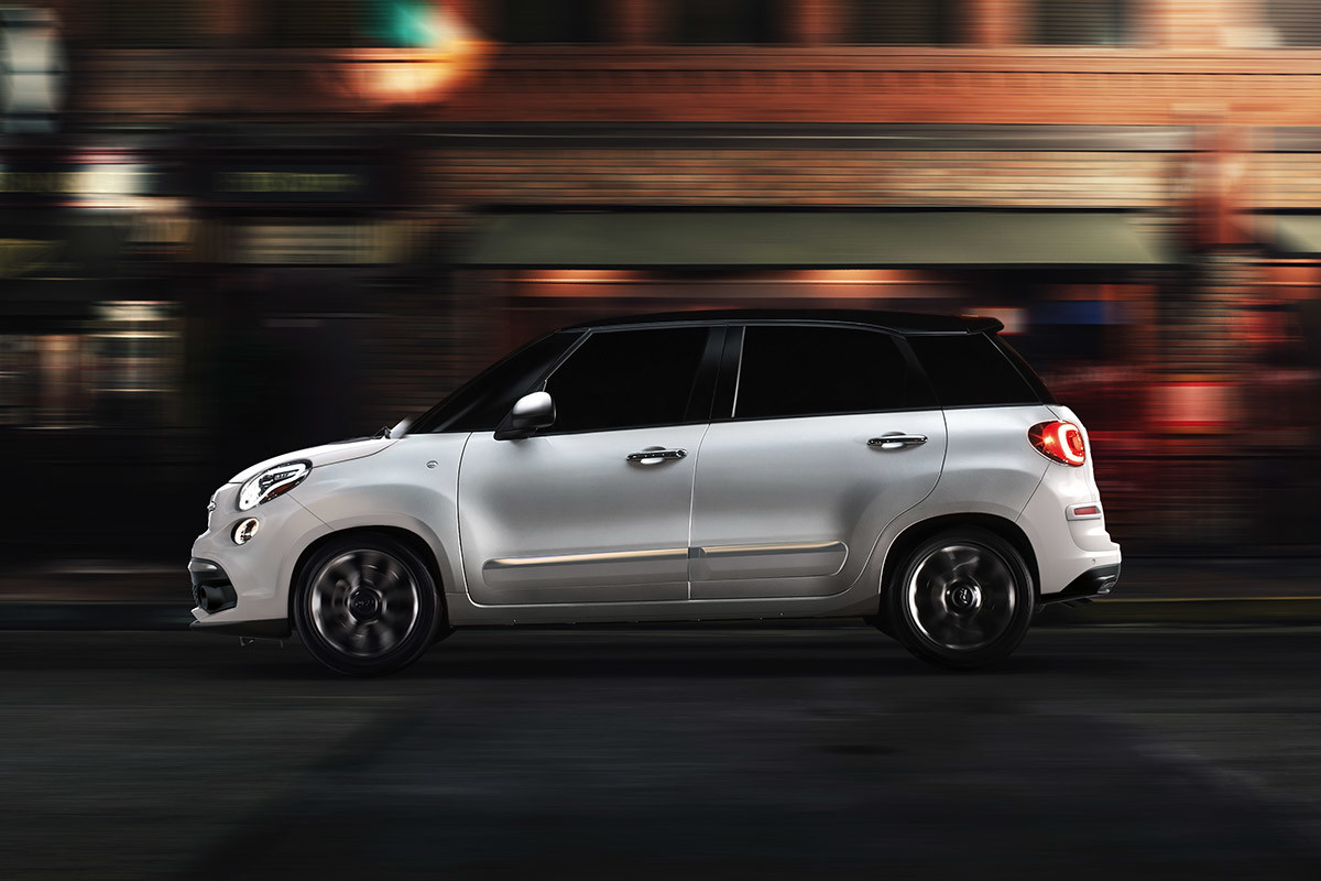 Vue latérale de la FIAT 500L 2019 garée dans une rue urbaine, illustrée en blanc