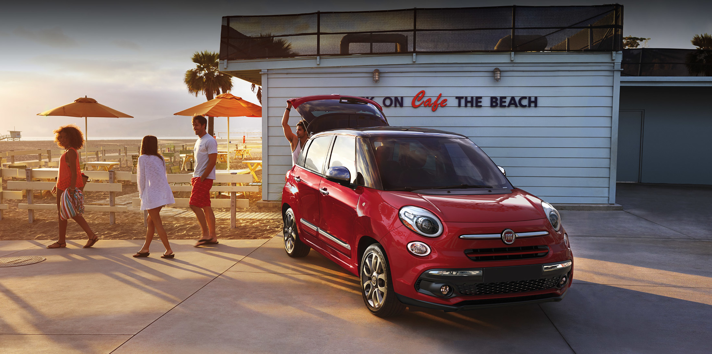 FIAT 500L 2020 rouge stationnée au bord de la plage pour une balade entre amis.