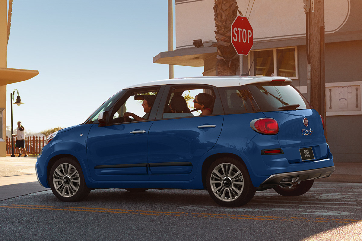 FIAT 500L 2020 attendant à un panneau d’arrêt alors que deux personnes regardent le véhicule