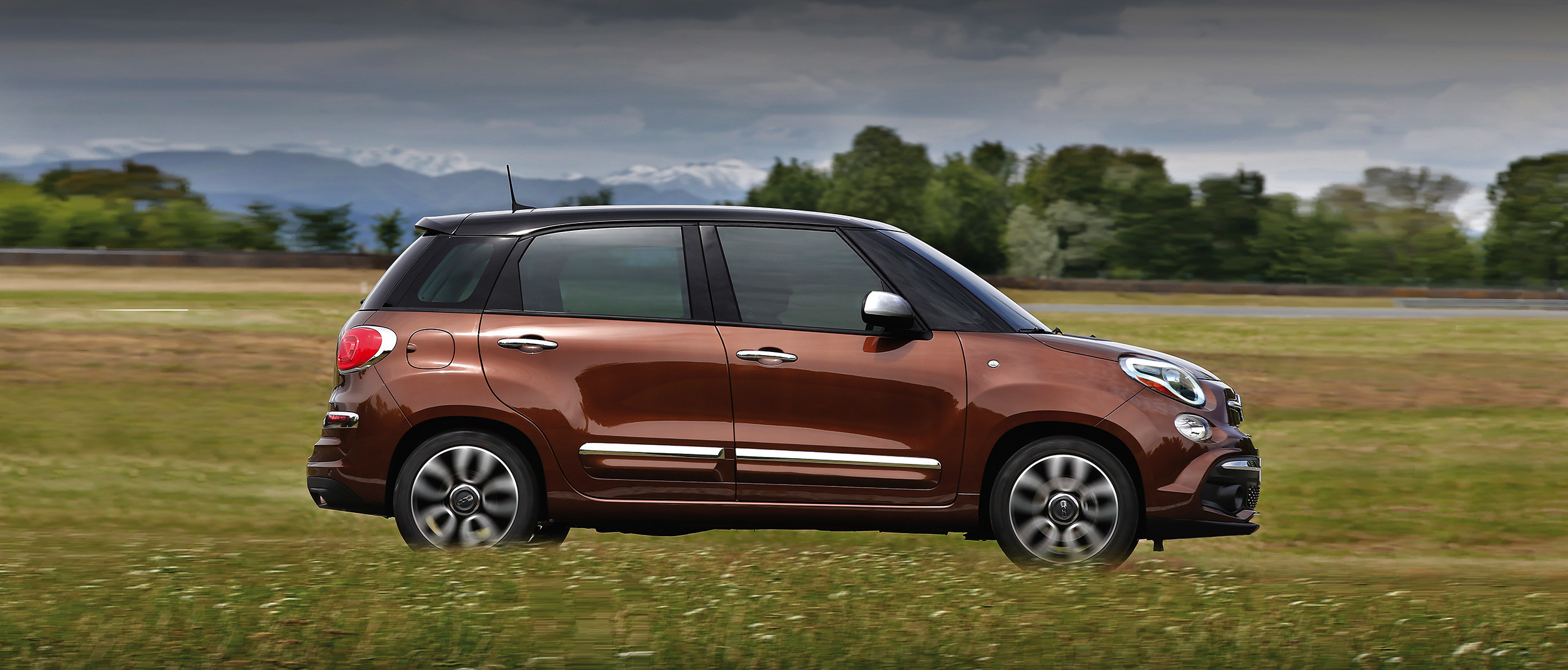 Side view of the 2020 Fiat 500L being driven on a country road through plains