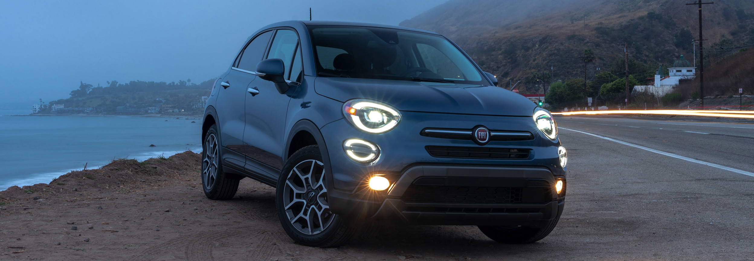 Grey 2020 FIAT 500X parked next to a beach in gloomy and foggy weather