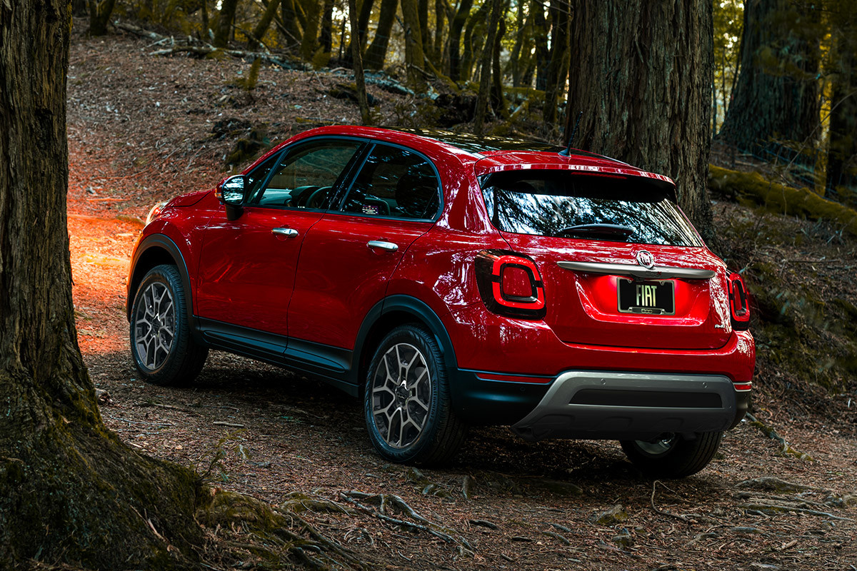 Une FIAT 500X 2020 rouge roulant à travers les arbres