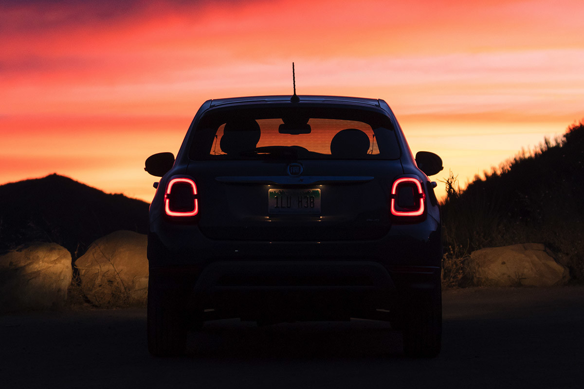 Vue arrière d’une FIAT 500X 2020 stationnée devant un coucher de soleil