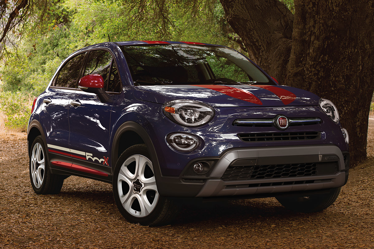 Side view of an Italia Blue 2021 FIAT 500X parked next to a tree