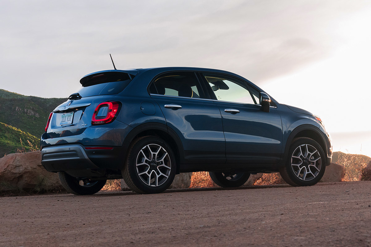 Side and rear view of a blue FIAT 500X parked on a dirt road