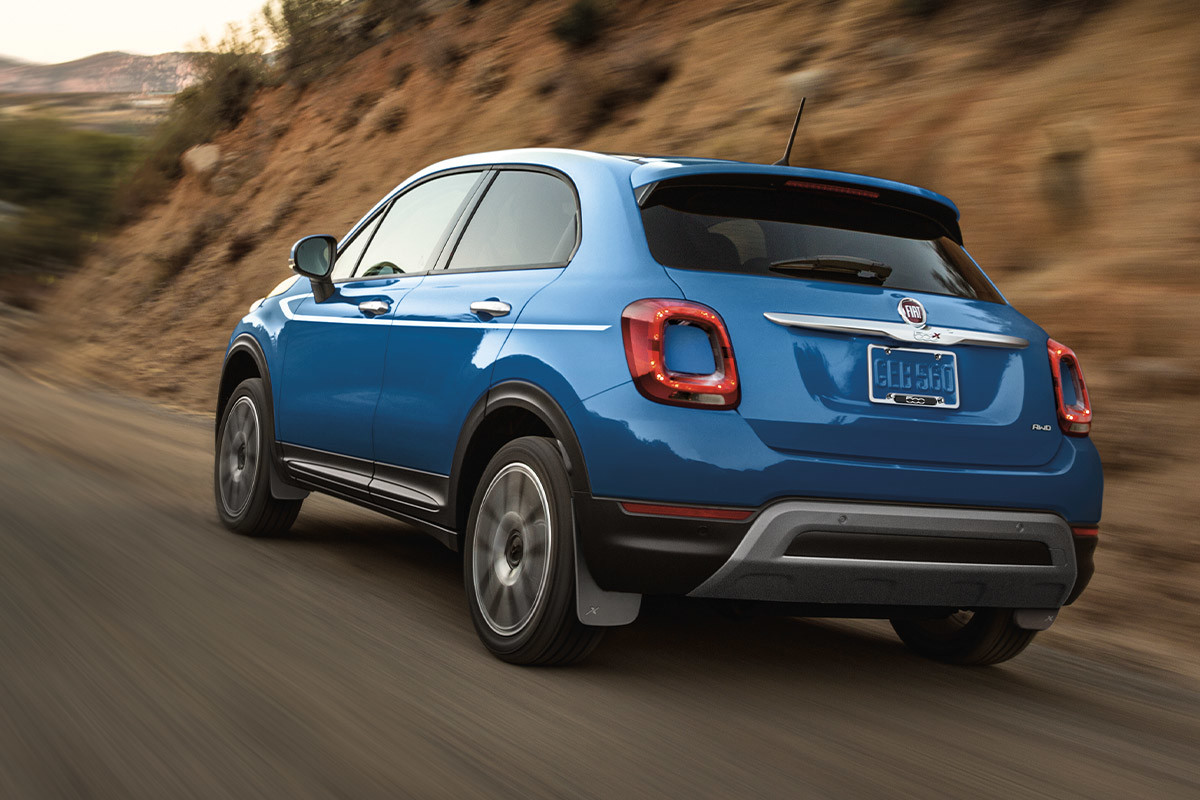 The back of a blue 2022 FIAT 500X driving down a highway.