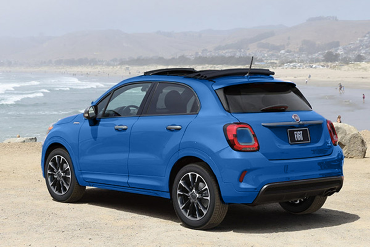 Le profil arrière d'une Fiat 500X rouge avec un toit souple ouvert.