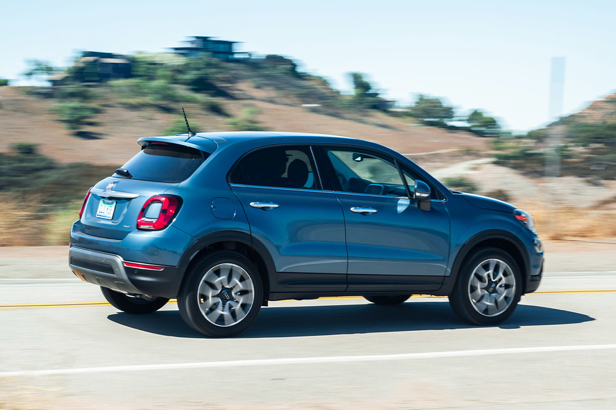 Vue latérale d’une FIAT 500X 2022 bleue roulant sur une autoroute.
