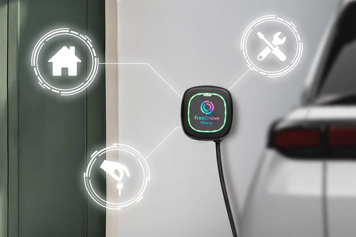A close-up of a Free2move Charge electric vehicle charger mounted on a wall, with a charging cable attached.