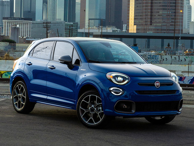 A blue FIAT 500X, parked in an urban city with skyscrapers in the background.
