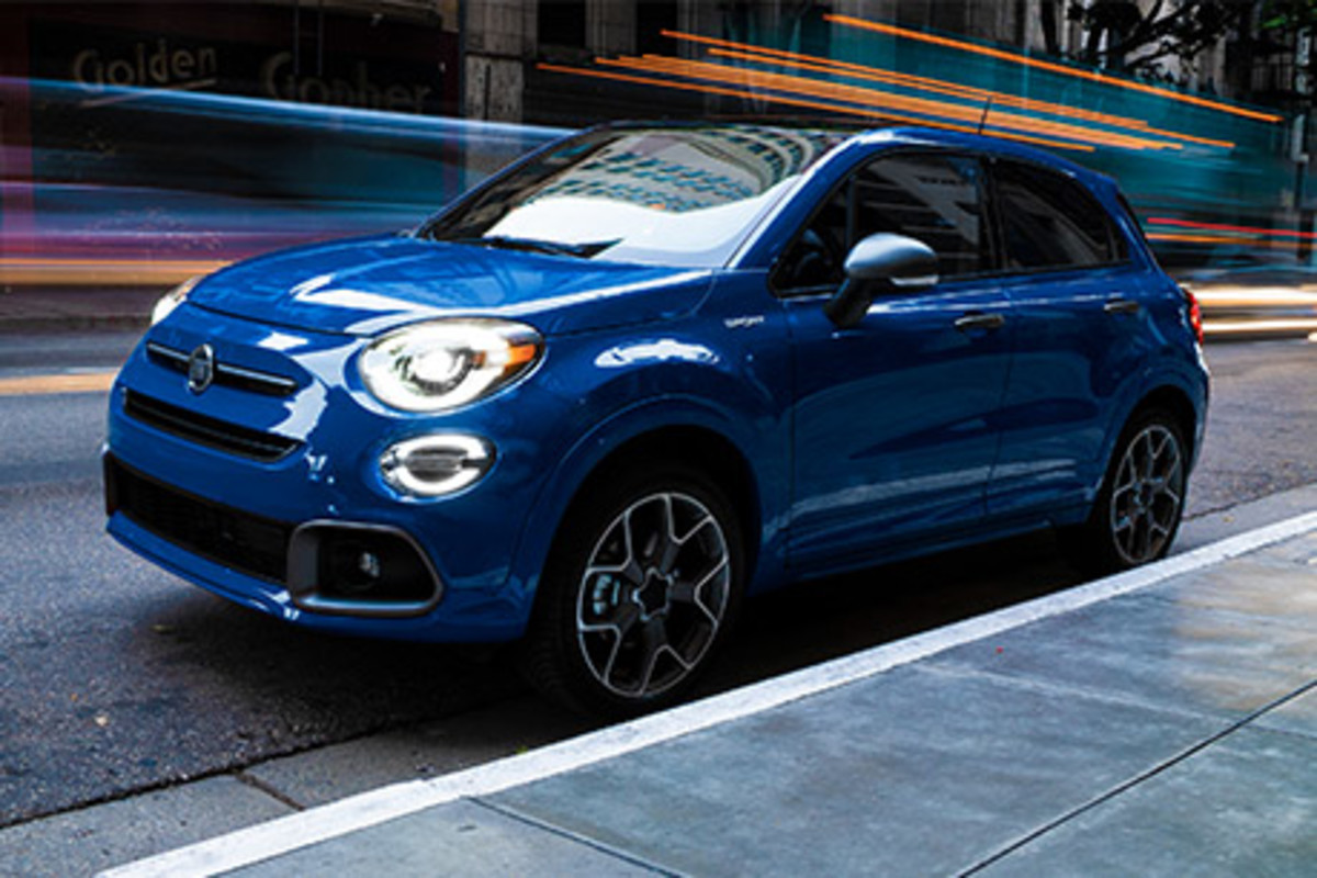 Une FIAT 500X bleue roulant sur une route de la ville.