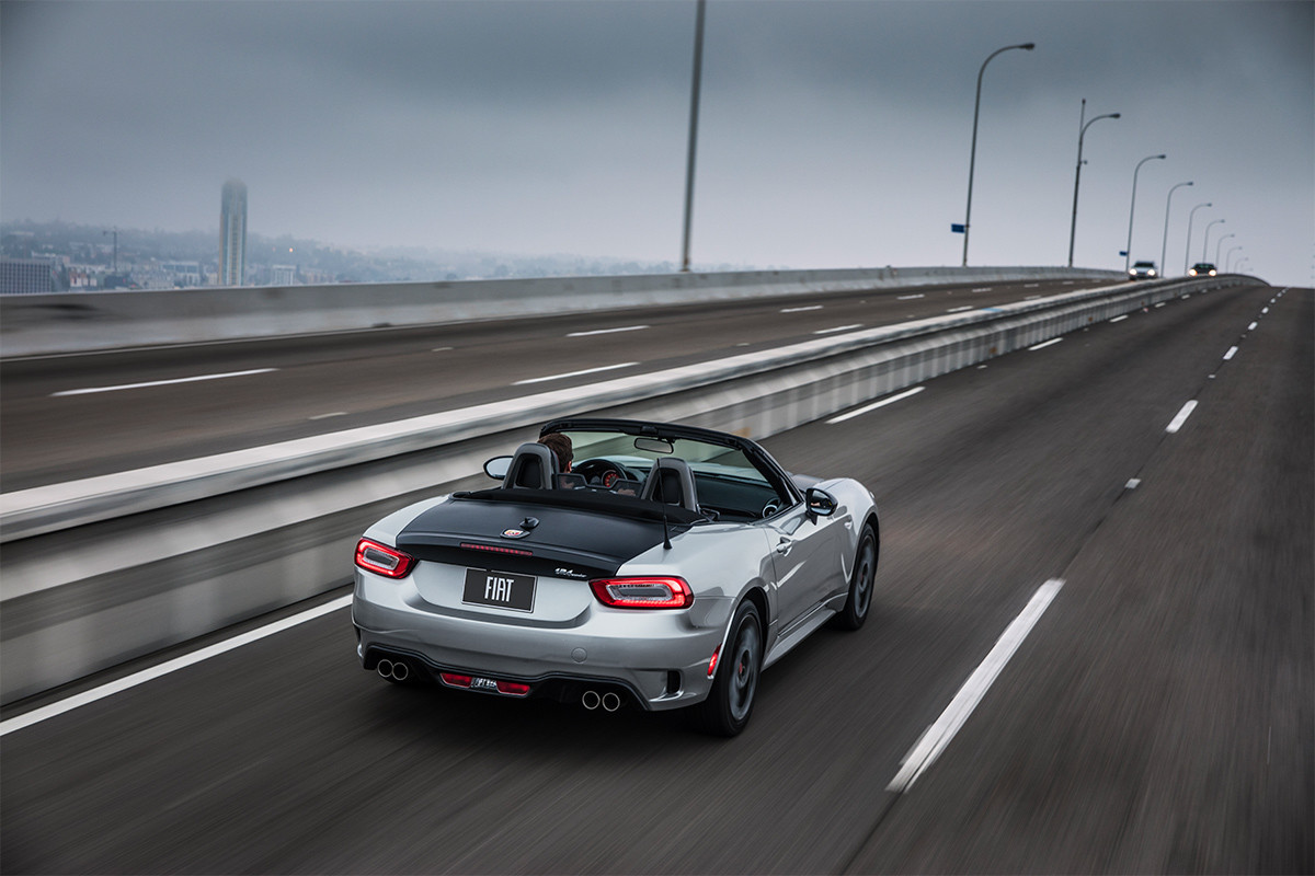 FIAT 124 Spider 2019 roulant sur l’autoroute, illustrée en blanc et noir