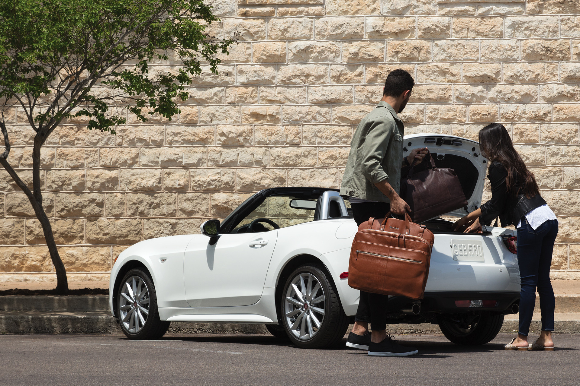 2019 Fiat 124 Spider parked with people unloading trunk, shown in white