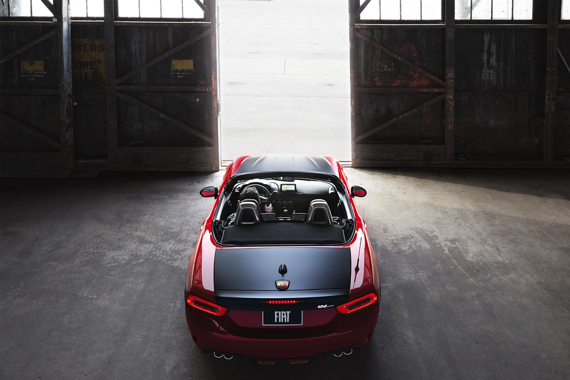 2019 Fiat 124 Spider rear aerial view in garage, shown in red and black
