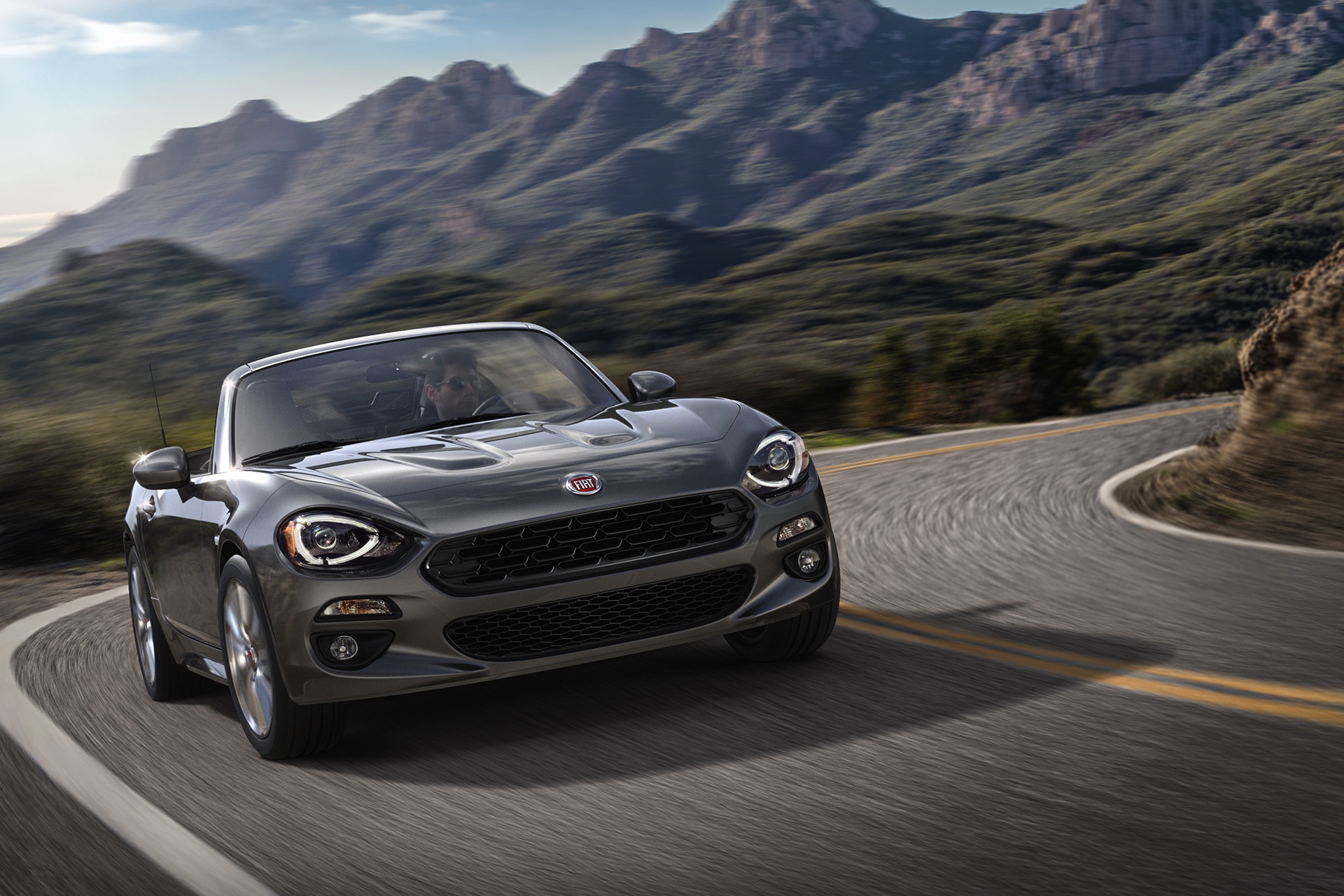 2019 Fiat 124 Spider driving down highway, shown in silver
