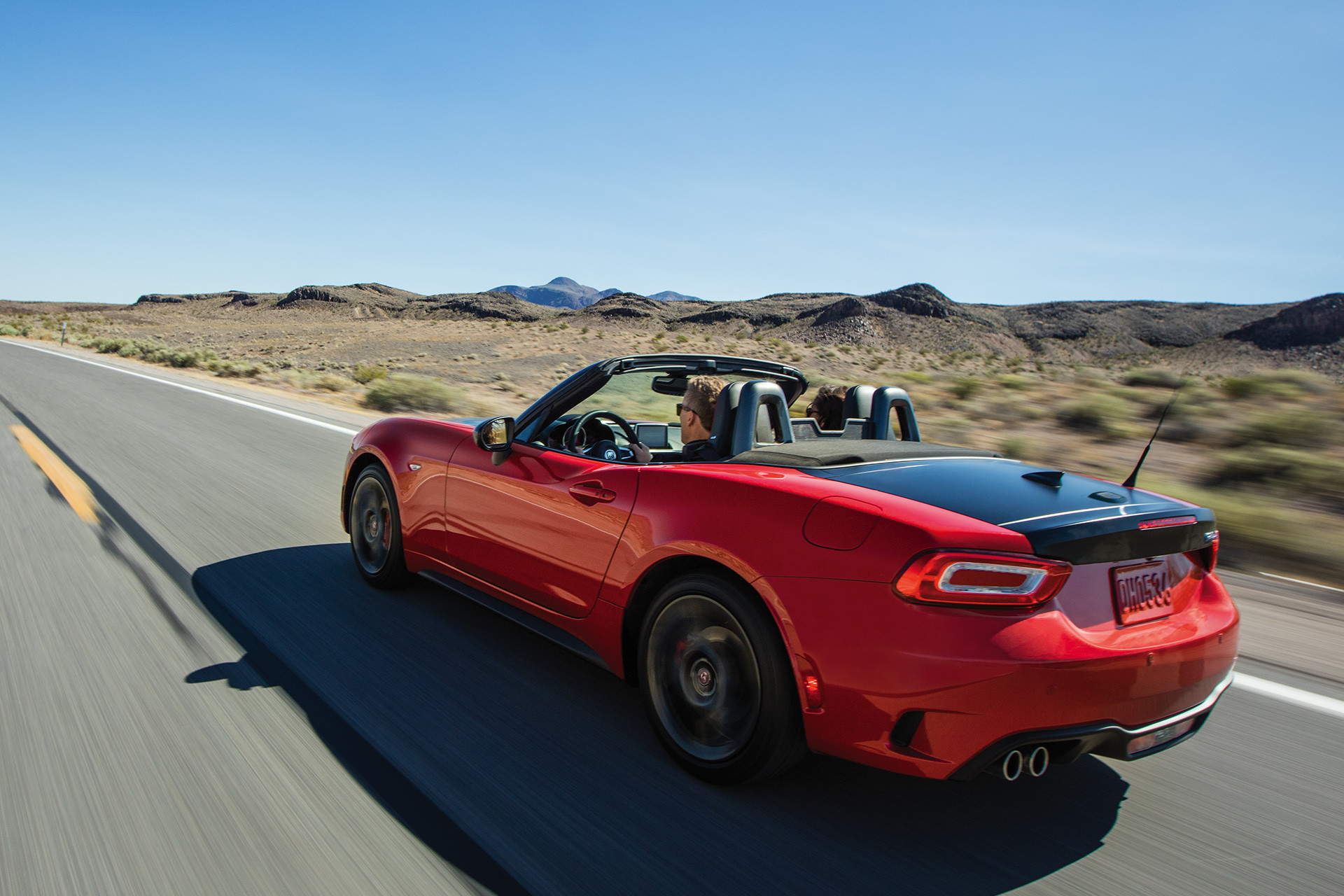 Red 2020 FIAT 124 Spider being driven on a road through the desert in a daytime