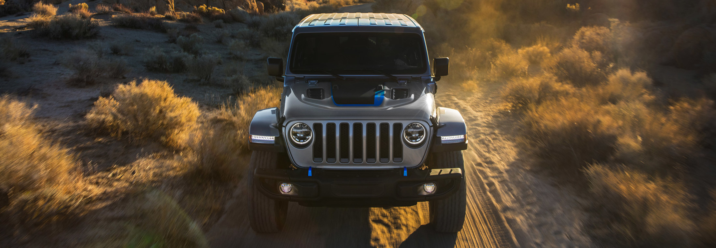 A grey 2021 Jeep Wrangler 4xe being driven through a desert.