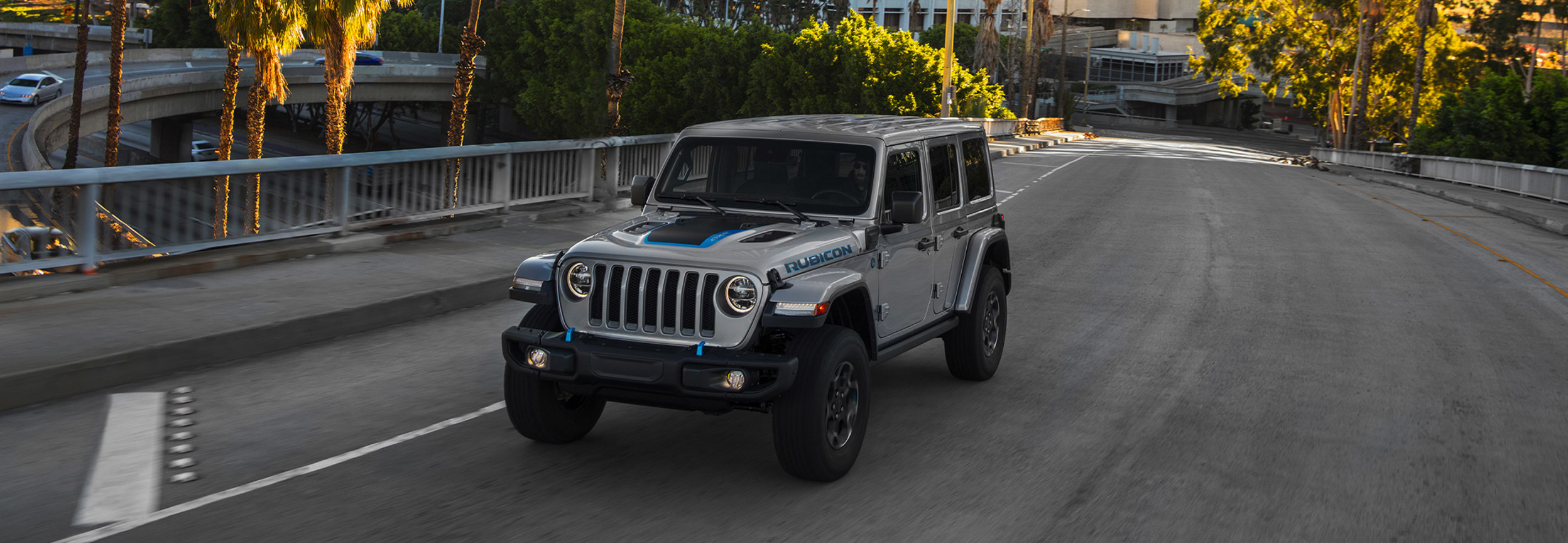 Jeep Wrangler 4xe 2021 de couleur grise conduite dans une rue calme.