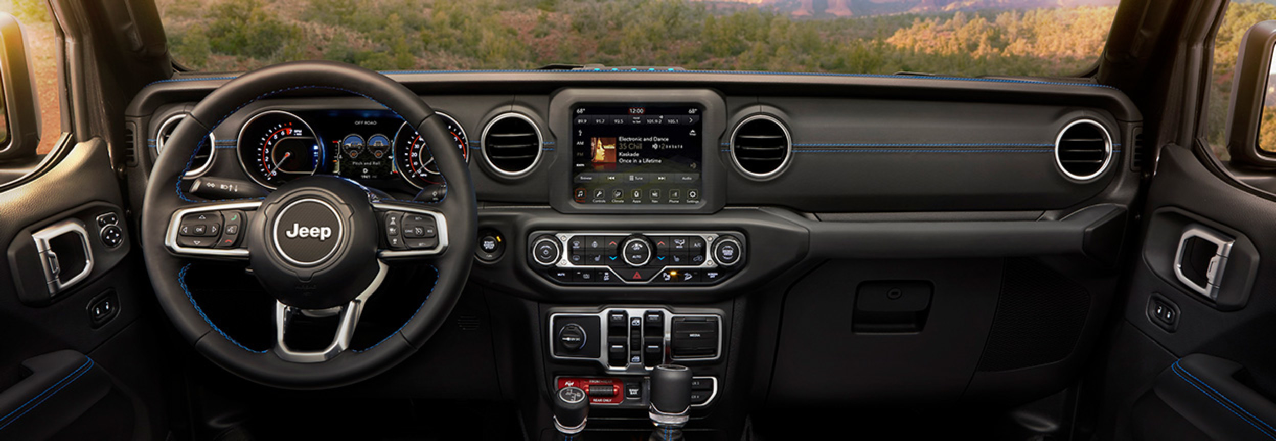Vue intérieure de l’avant d’un Jeep Wrangler 4xe, illustrant les sièges passager et conducteur ainsi que la console centrale.