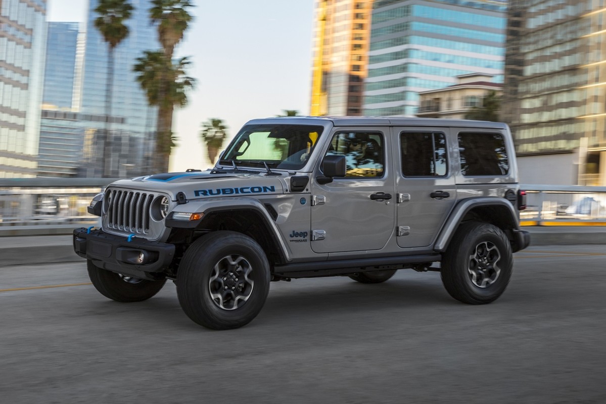 Le nouveau Jeep Wrangler 4xe 2021 roulant sur une autoroute avec la ville en arrière-plan.
