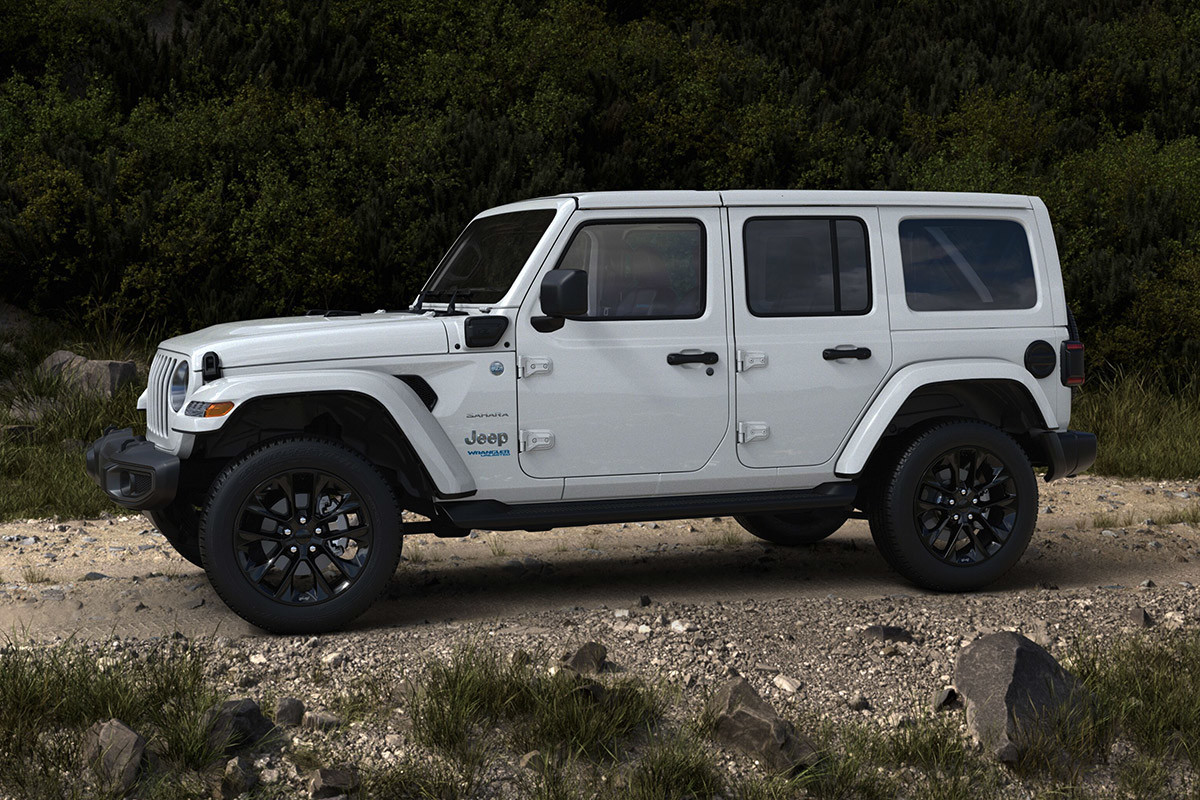 Vue latérale d'un Jeep Wrangler 4xe 2021 blanc garé sur un chemin de terre.