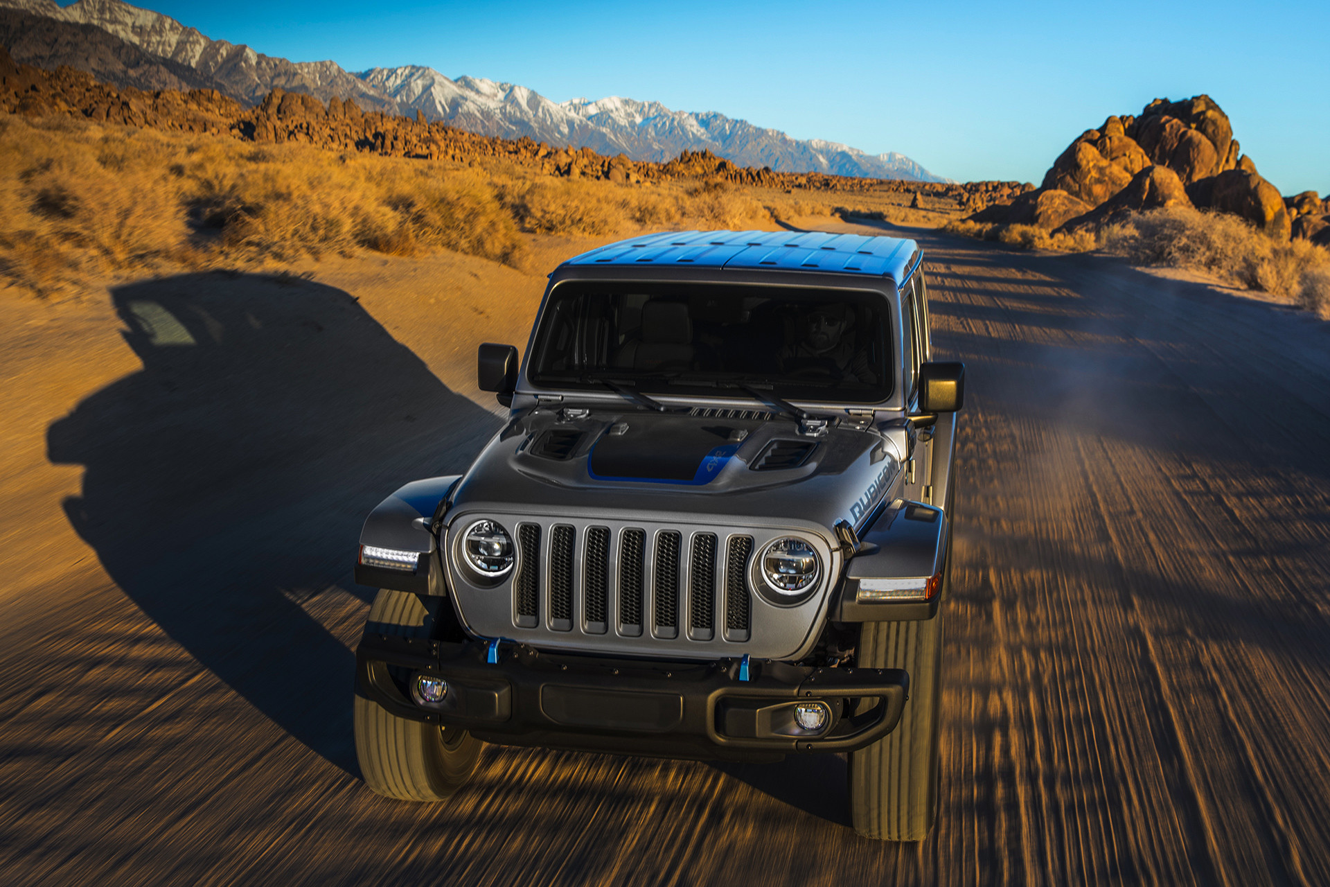 Vue avant du Jeep Wrangler 4xe 2021 roulant sur une route de terre.