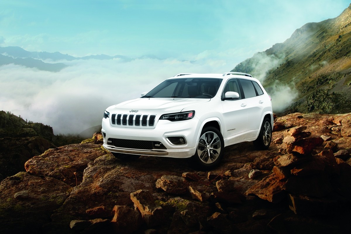 The white 2020 Jeep Cherokee parked on a peak of a rocky mountain