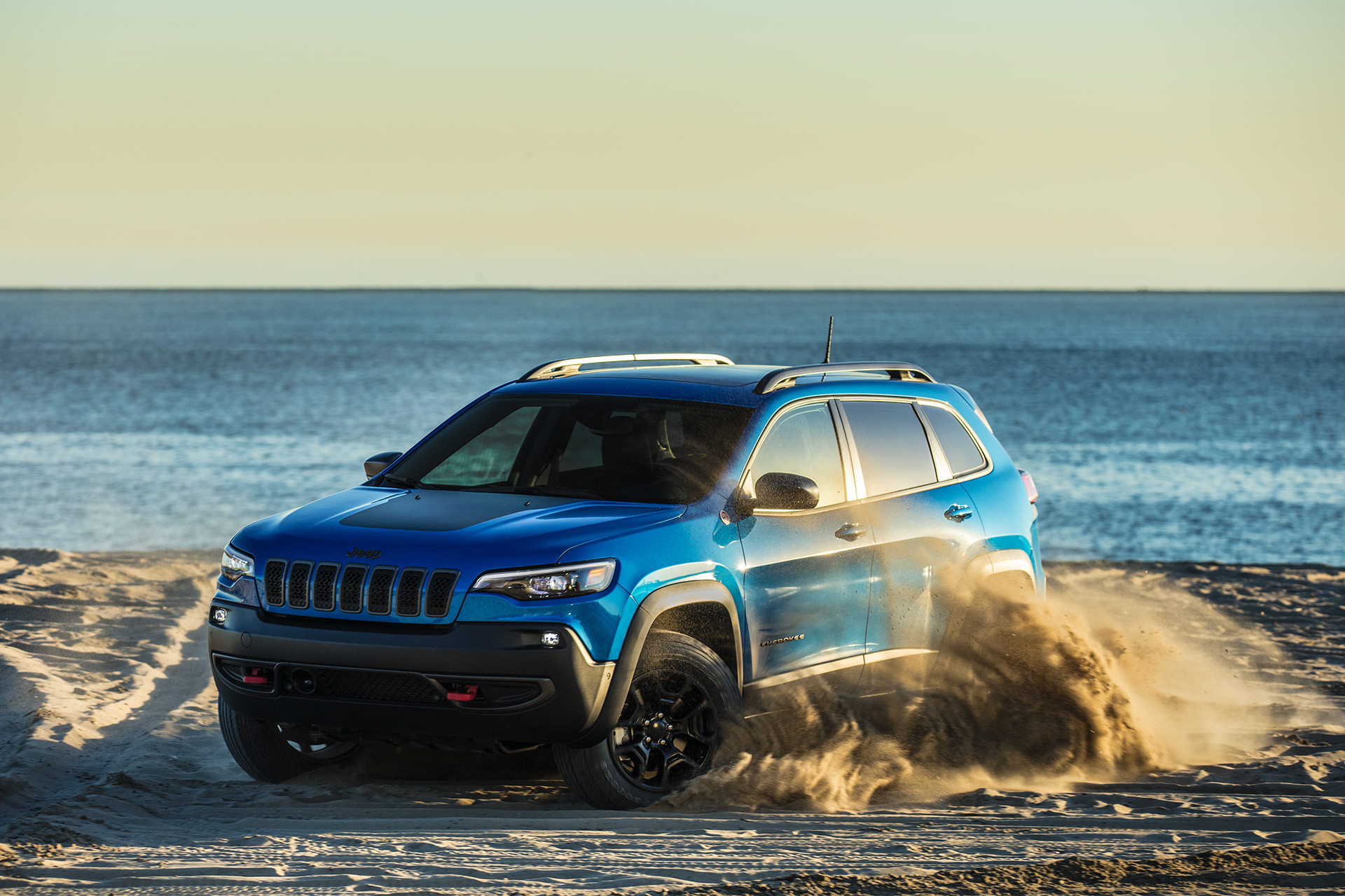 Blue 2020 Jeep Cherokee being driven on beach highlighting its offroad capacity