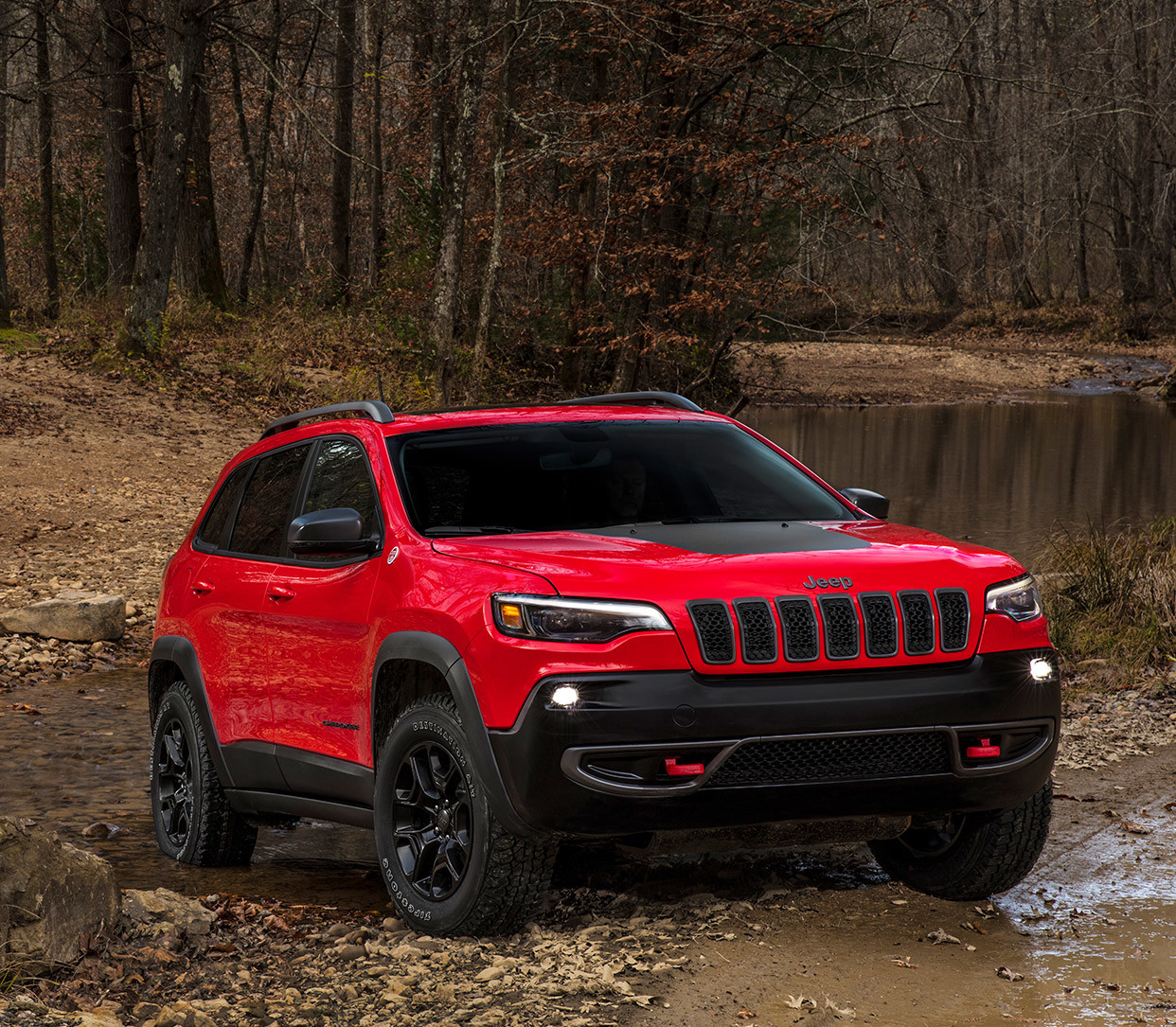 Un Jeep Grand Cherokee 2020 rouge stationné dans la forêt