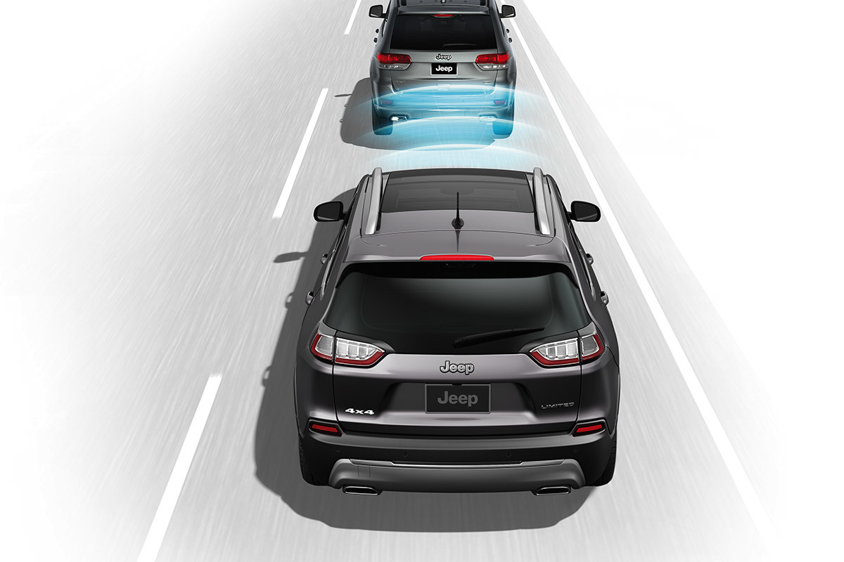 Graphic of a 2021 Jeep Cherokee in traffic. Adaptive Cruise Control sensors are visually represented by a series of arced lines radiating from the front bumper towards the vehicle ahead.