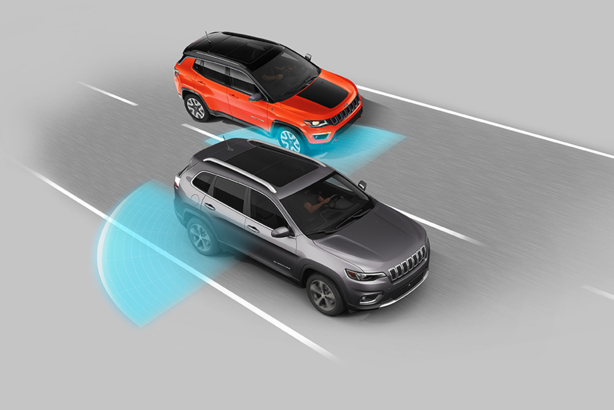 An overhead view of a Billet Metallic 2021 Jeep Cherokee with an orange vehicle in its blind spot. Illustrated blue sensors emanate from the either side of the rear half of the vehicle.