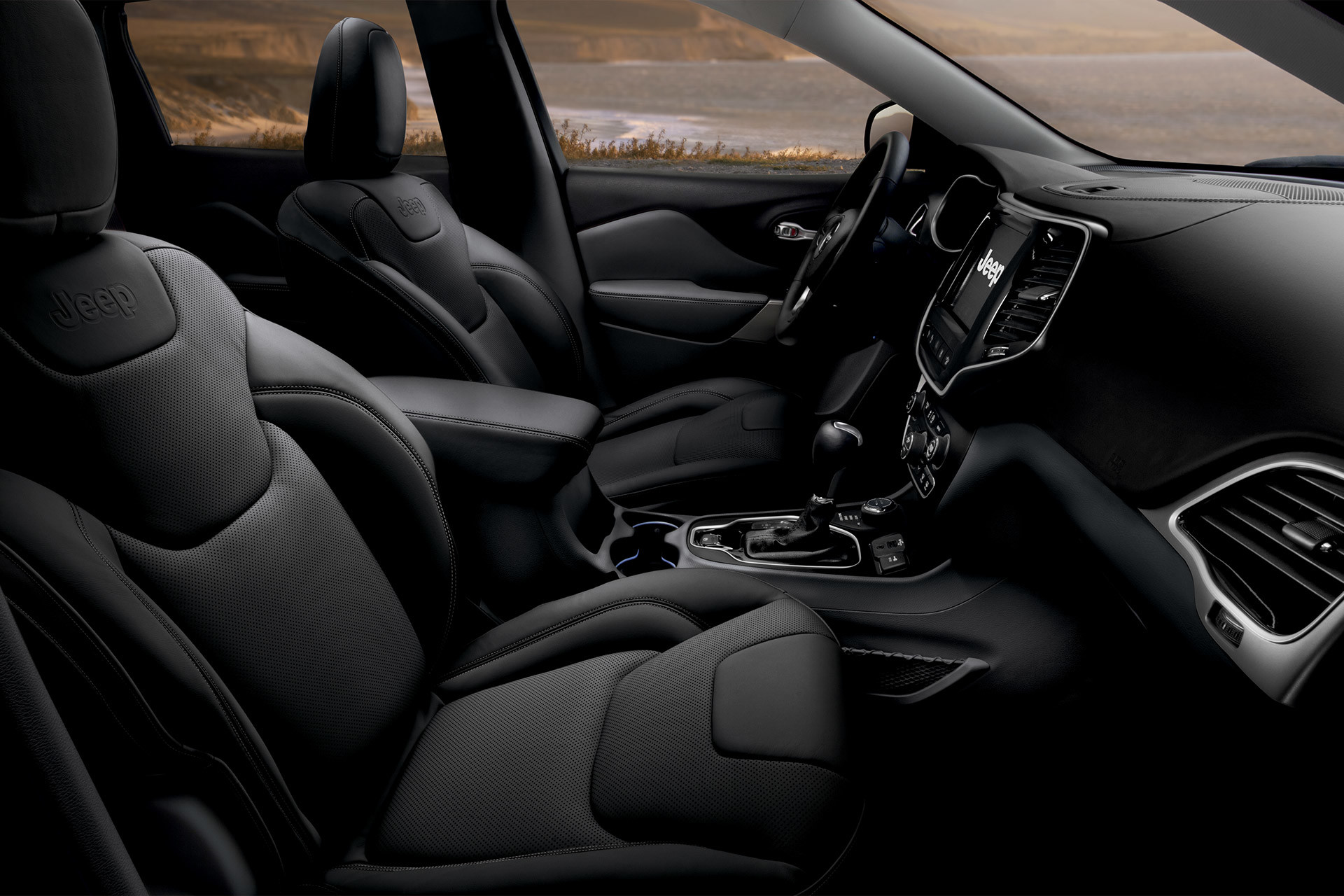 2022 Cherokee Limited Intérieur en sièges garnis de cuir noir avec côte vue à travers les fenêtres.