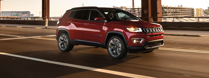 Red 2019 Jeep Compass being driven on a city road.