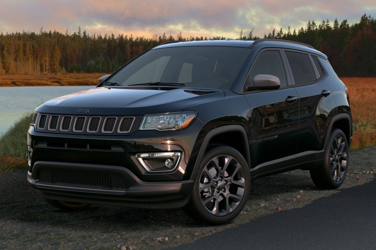 Jeep Compass en noir garé sur le bord de la route au bord d'un lac.