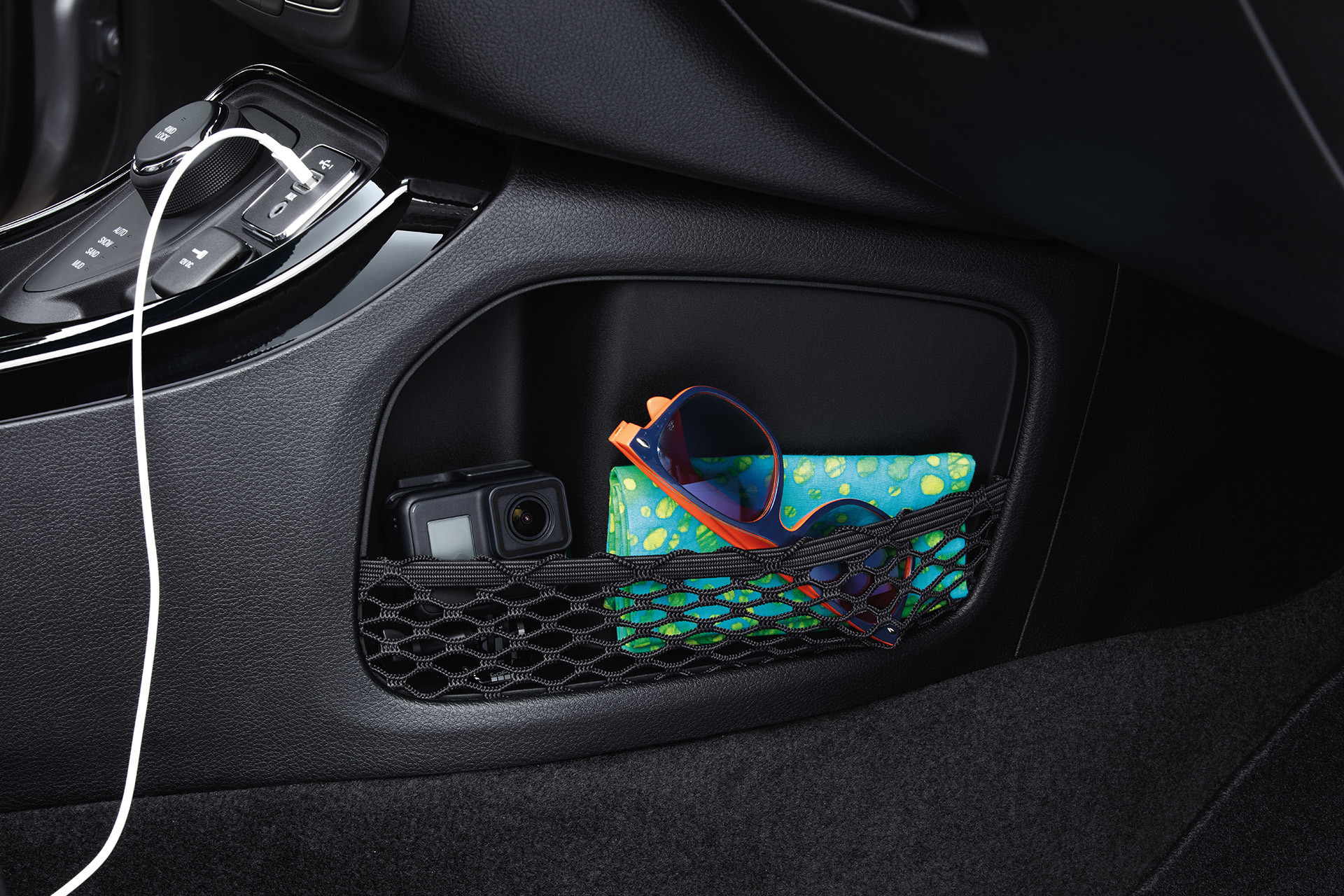 Interior compartment with mesh pocket holds personal belongings such as sunglasses and a camera.