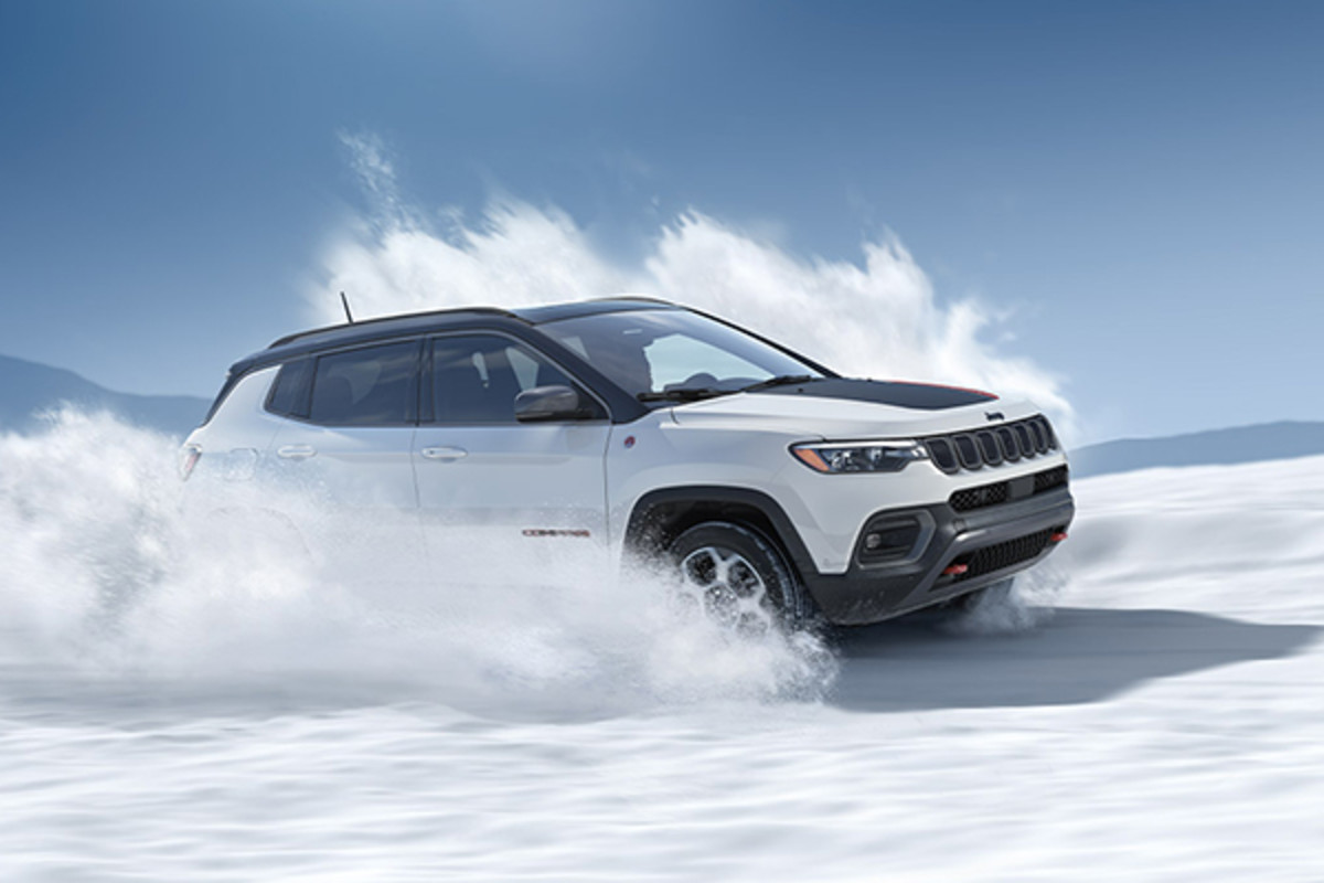 Compass Trailhawk blanc éclatant roulant dans la neige.