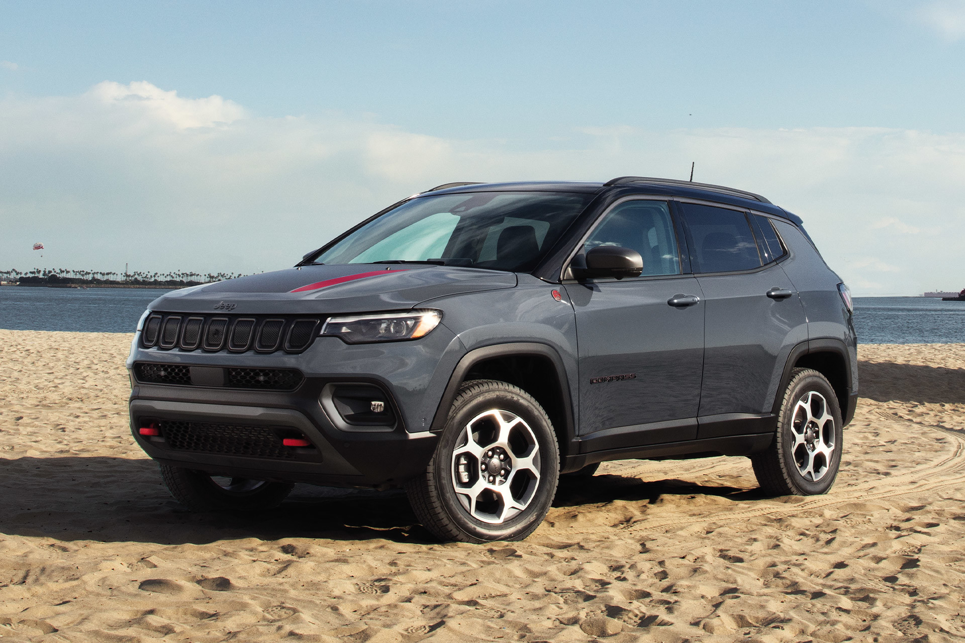 Un Jeep Compass 2022 gris garé sur une plage de sable