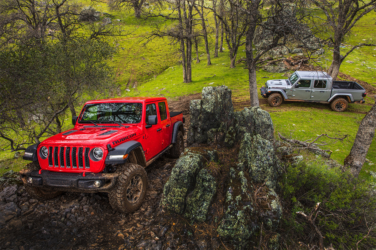 Jeep Gladiator 2020 rouge gravissant une pente rocheuse suivi par un Jeep Gladiator 2020 gris.