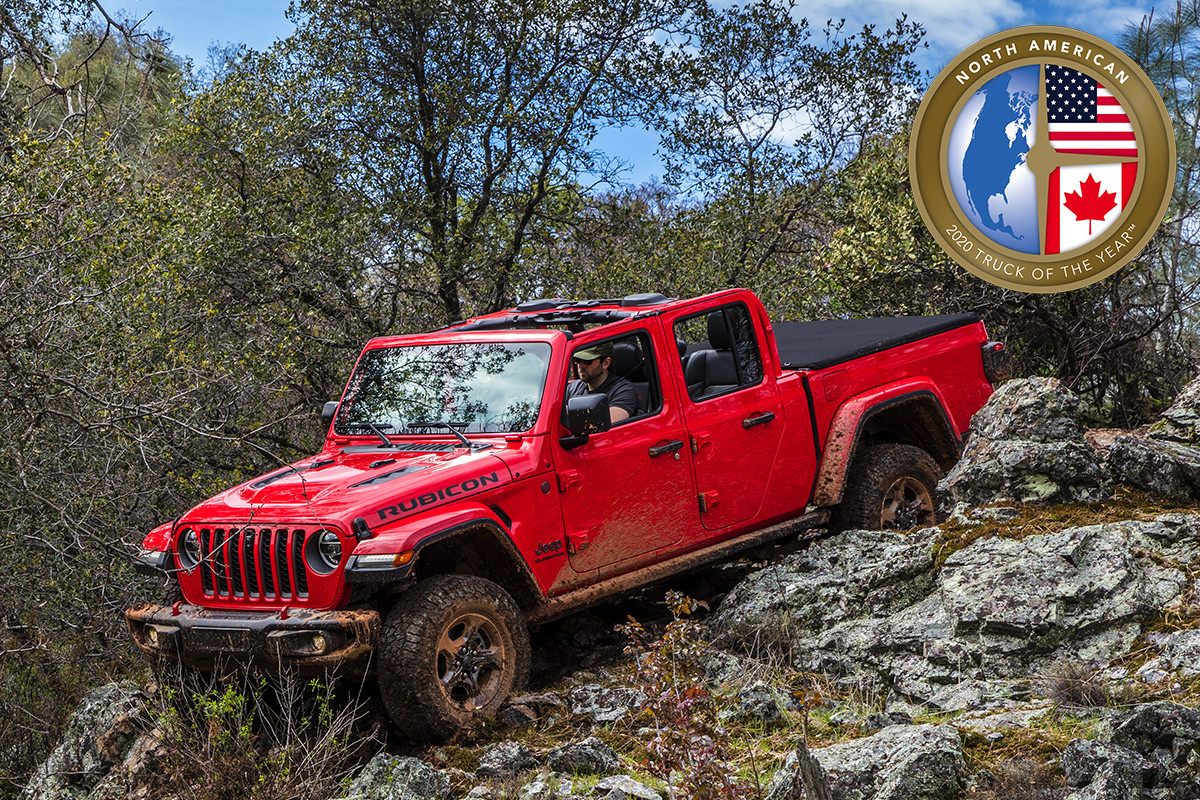 A red 2020 Jeep Gladiator, the winner of the 2020 North American Truck of The Year, driving through the rocks in a mountain