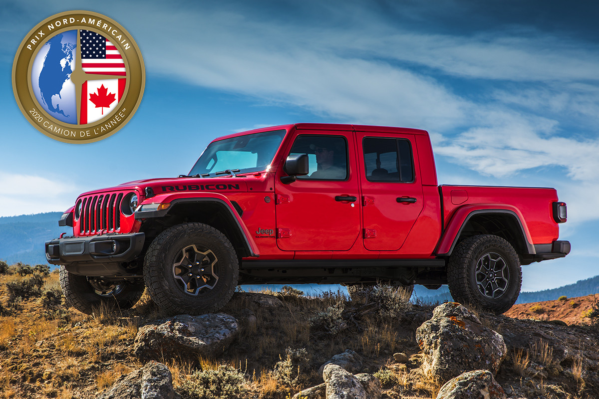 Un Jeep Gladiator 2020 rouge, le gagnant du prix « Camion nord-américain de l’année 2020 », stationné au sommet d’une colline dans le désert.