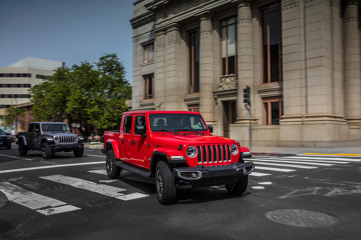 Extérieur du Jeep Gladiator 2020 roulant en ville, illustré en gris et rouge.