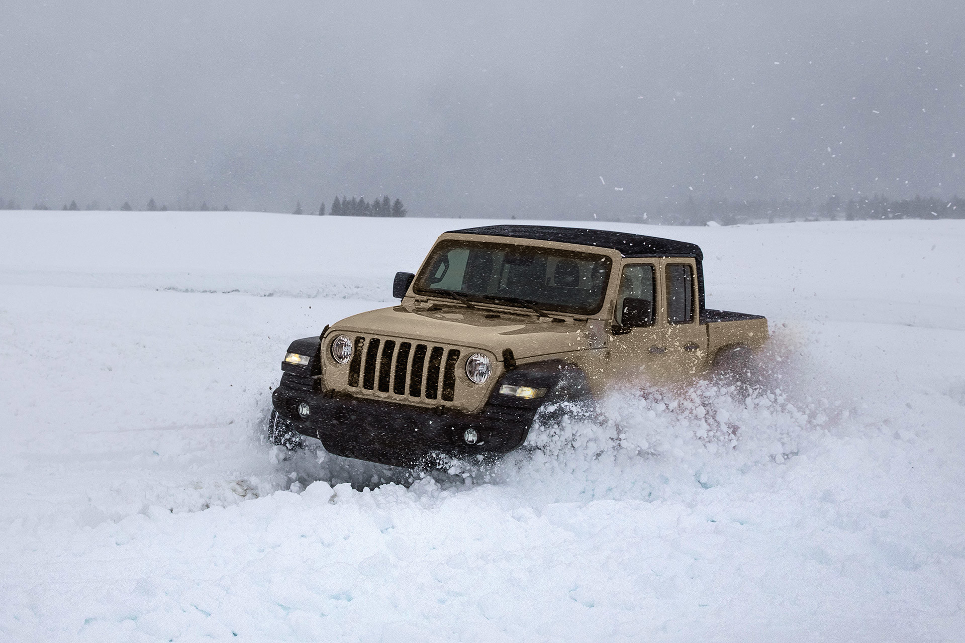 Front view of the all-new 2020 Jeep Gladiator in Gobi driving through a snowy field