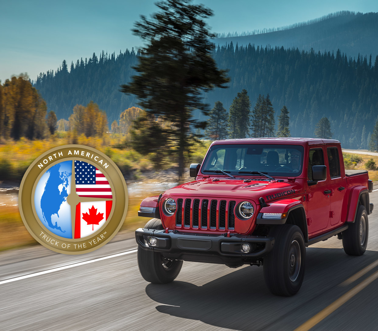 A red 2020 Jeep Wrangler being driven down the road with mountains in the background
