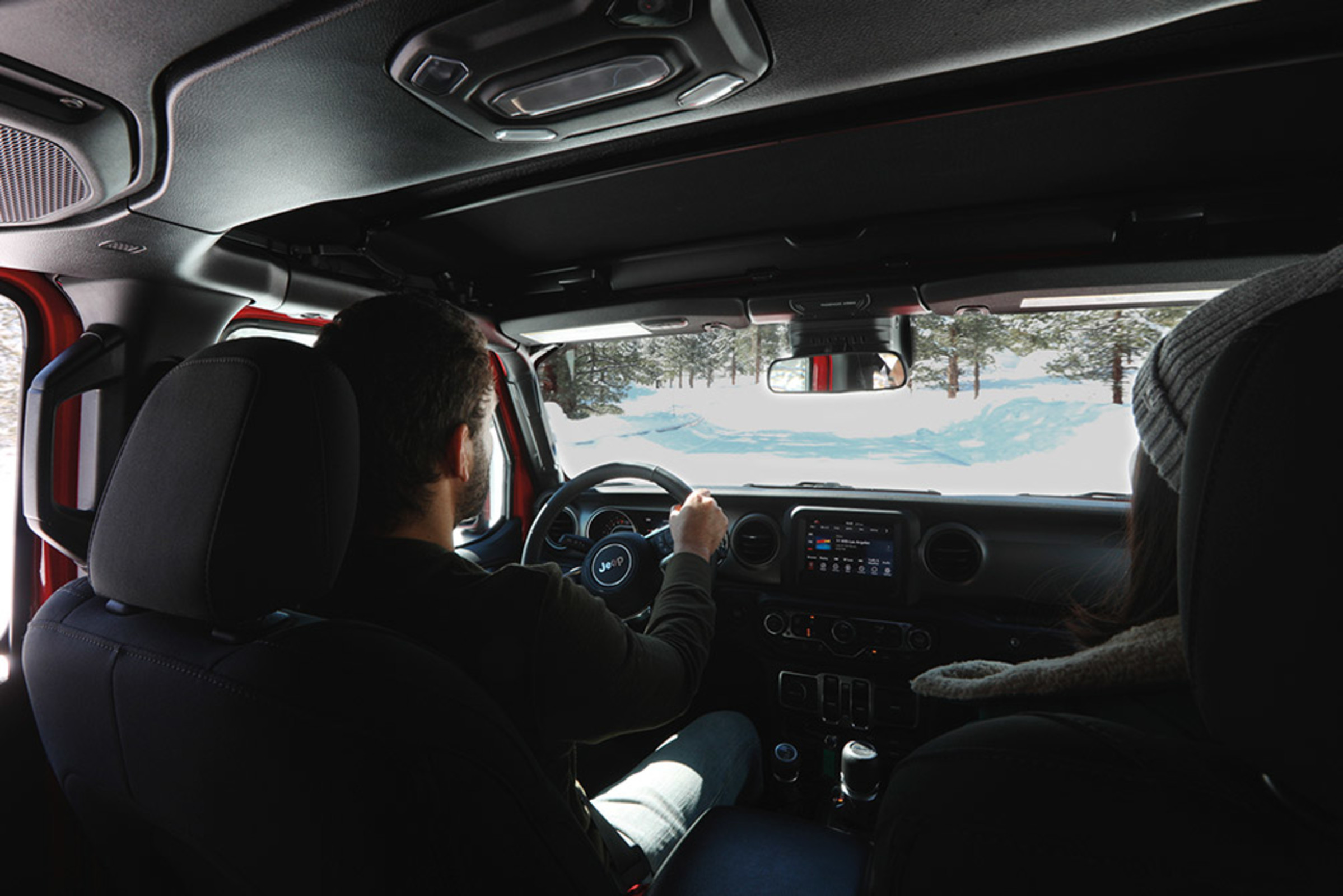 Vue arrière d’un homme assis dans le siège du conducteur d’un Jeep Gladiator 2021.