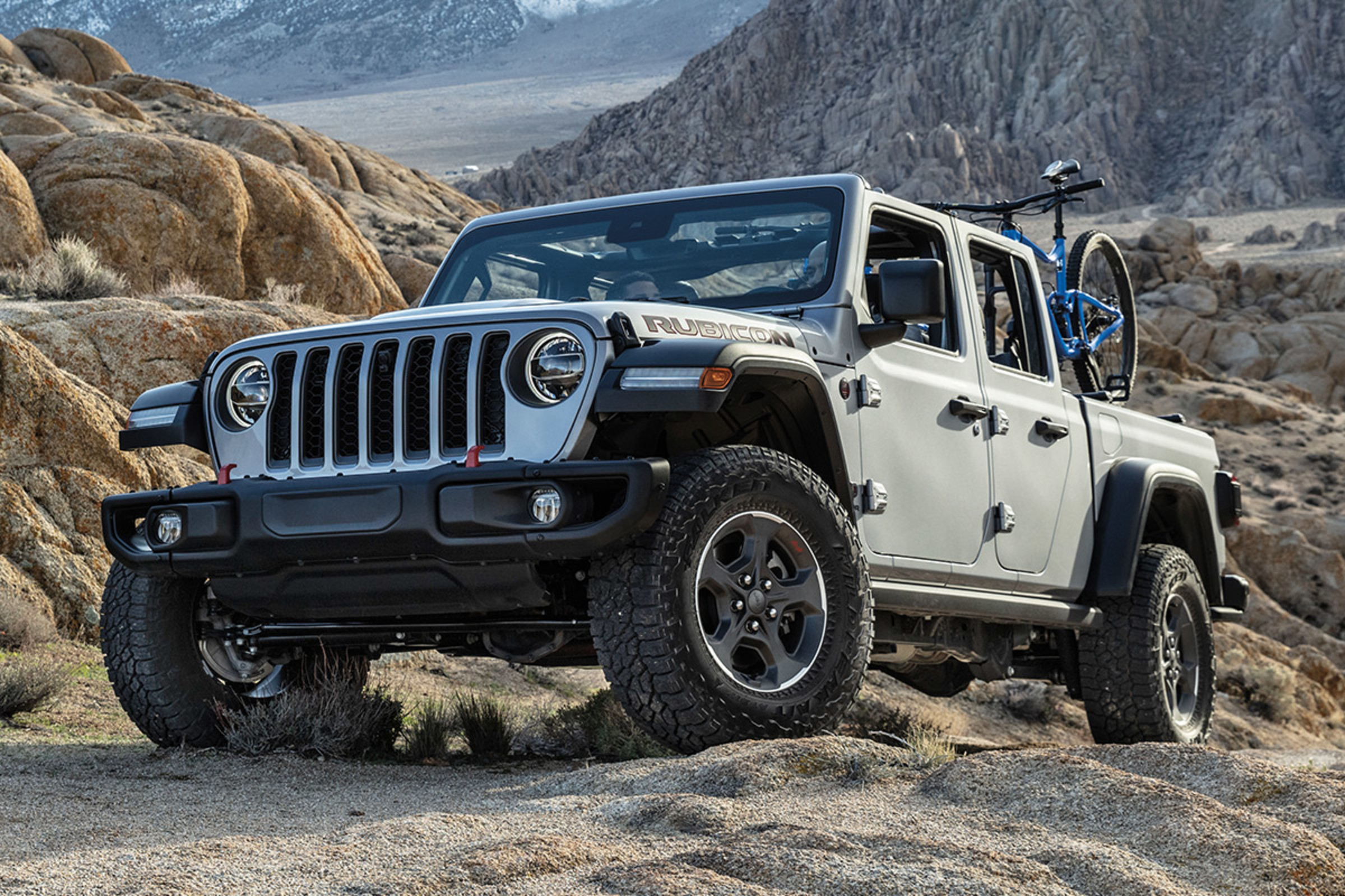 Jeep Gladiator garée dans le désert entourée de falaises rocheuses
