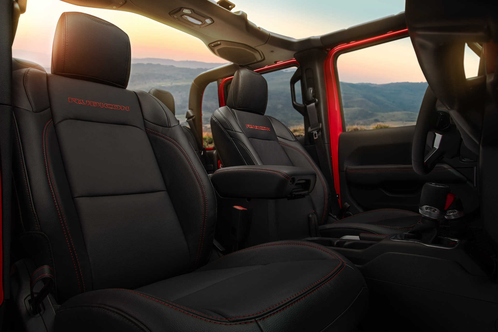 Interior shot of the open-roof Jeep Gladiator front seats,with a mountain in the background.