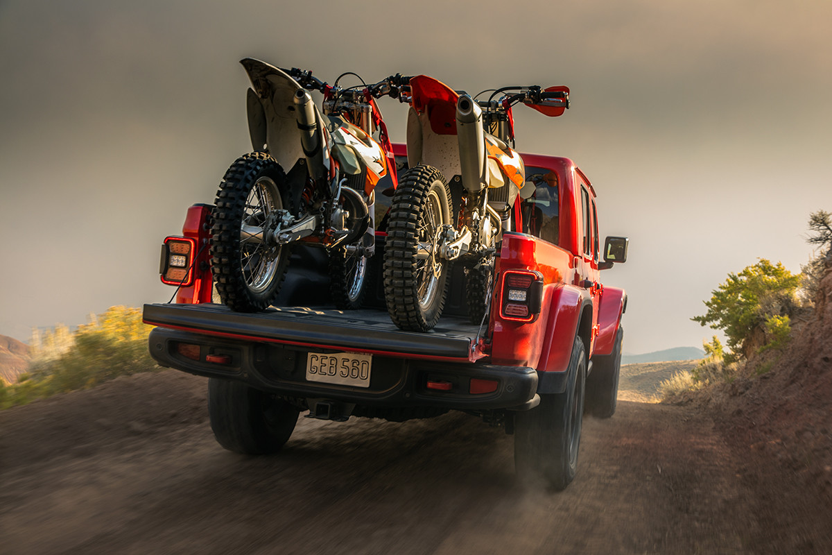 L’arrière d’un Jeep Gladiator 2022 rouge avec deux motos tout-terrain dans la caisse.