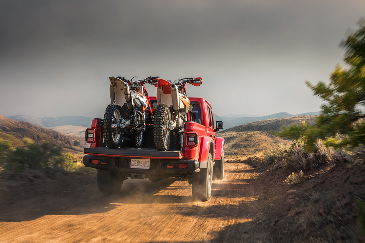 The back of a red 2022 Jeep Gladiator with two dirt bikes in the truck bed.