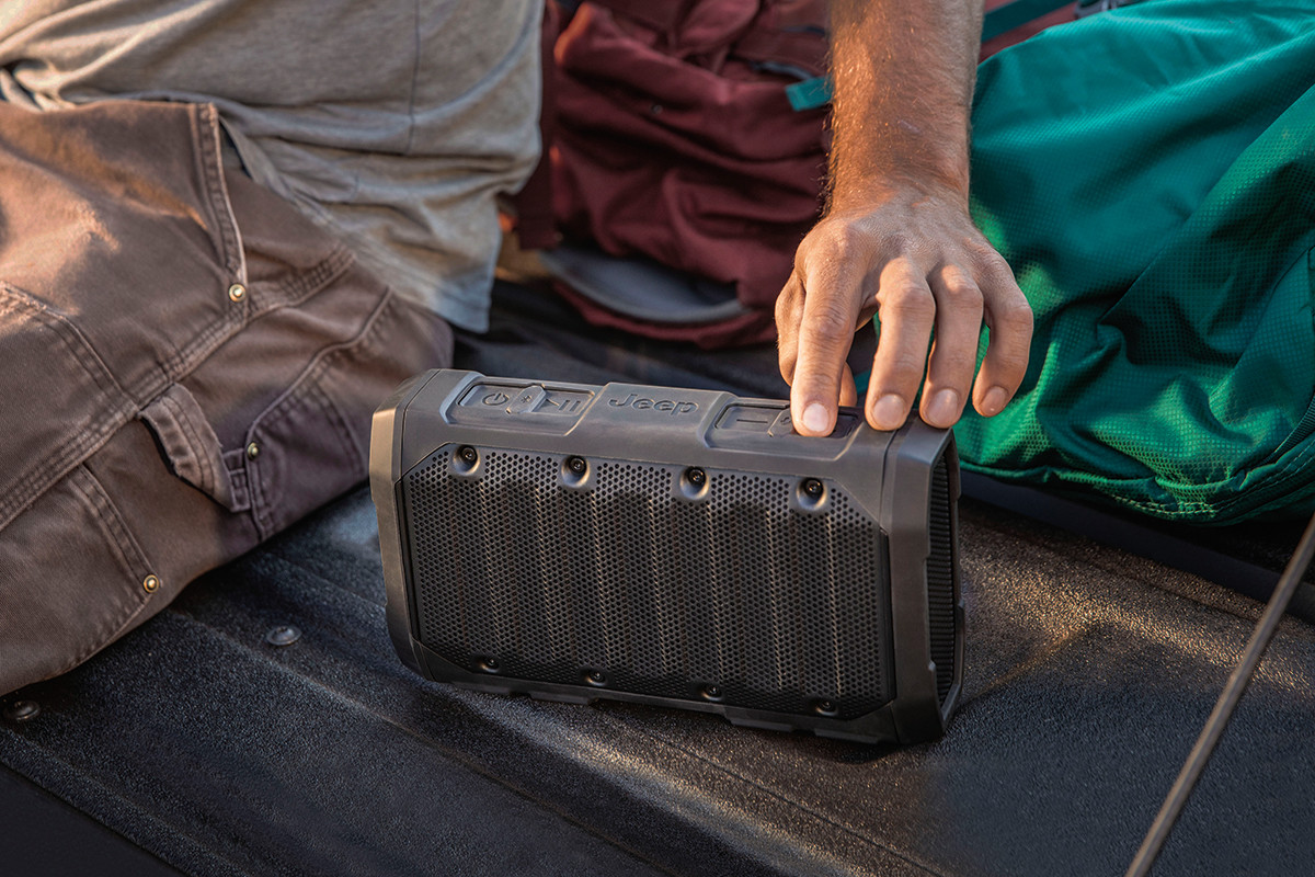 Gros plan d’une personne utilisant un haut-parleur Bluetooth de marque Jeep.